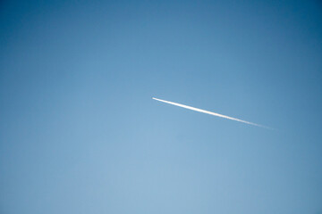 Airplane flying in the blue sky . Large airplane flying high in clear blue sky, leaving long white trail