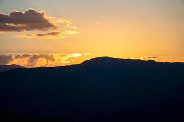 Colorful morning silhouettes of coniferous forest Beautiful sunset in the mountains