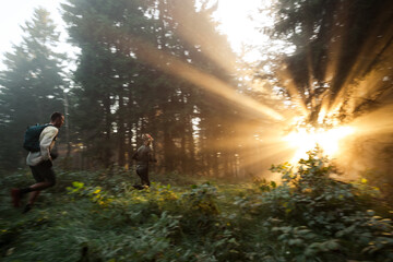 Läufer laufen im Wald bei aufgehender Sonne