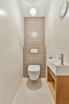 Modern bathroom interior with toilet bowl under bright lamp
