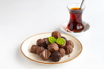 Variety of luxury chocolates on a white background. Along with a cup of tea