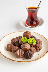 Variety of luxury chocolates on a white background. Along with a cup of tea