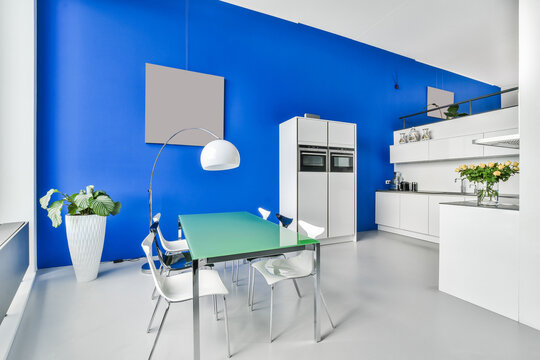 Modern kitchen interior with fridge against table at home