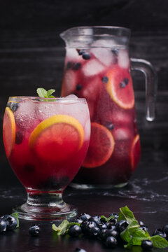 Lemonade with blueberries and lemon on table