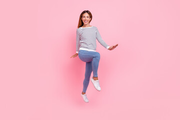 Photo of adorable charming young woman dressed striped pullover jumping high walking isolated pink color background
