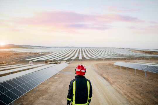 Unrecognizable workman looking at solar panels