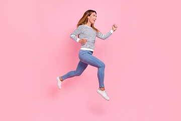 Fototapeta na wymiar Photo of pretty funky mature lady wear striped sweater smiling jumping running fast looking empty space isolated pink color background