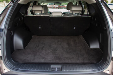 Huge, clean and empty car trunk in interior of a modern compact suv. Rear view of a SUV car with open trunk. Car trunk interior.