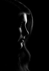 silhouette of a girl's face with wavy hair on a black background