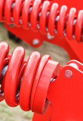 Hard red spring made of steel. Part of big industrial or agricultural machine