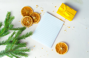 a kind of Christmas background with an empty sheet of paper, writing goals on a white wooden background, free space. Flat layout, top view