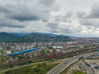 Drone view of the road, railway trains, mountains in Batumi on a summer day.