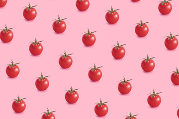 Repetitive pattern with cherry tomatoes on pink background. Minimal food background.