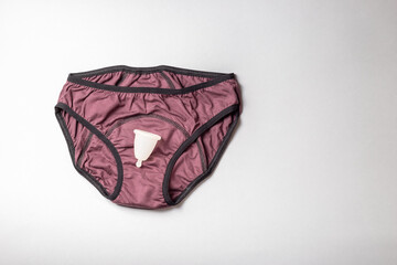 Period underwear panties and menstrual cup on grey