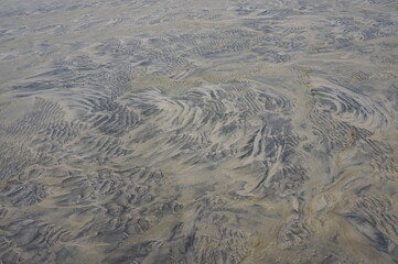 Swirls of Tan and Black Wet Sand Suitable at Background