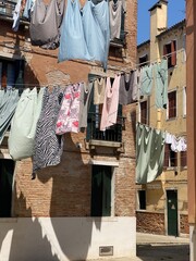 Hanging clothes put to dry on a small traditional street of Venice, Italy. Travel background