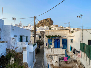 Fototapeta na wymiar Pedestrian street of Greek Chora village built around a large rock on Amorgos island, Aegean Sea, Cyclades, Greece