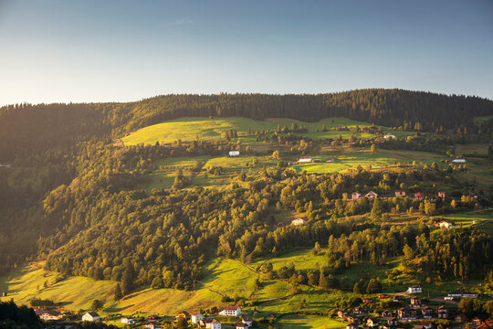 Sunrise over landscape with small town in hills of La Bresse, Vosges, France