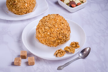 Brownie with walnuts on white plate on marble