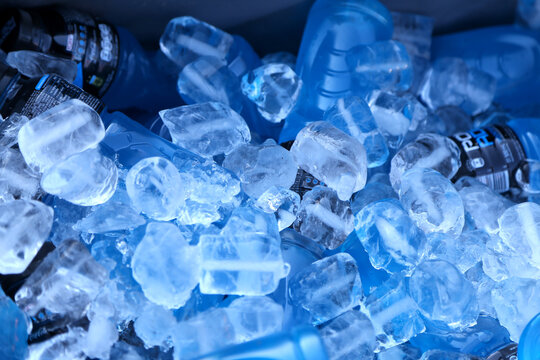 Ice. Cold drinks. Drinks on ice.  Powerade energy drink. Blue bottle chilling between ice. Drink for athletes. Mountain Blast flavor drink. Blue liquid. Drink for sports or physical activities.