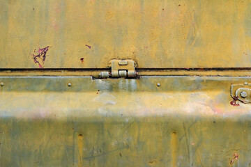 Photo of old and rusty military vehicle armored surface plates with hinge.