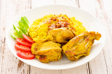 Khao Mok Gai, Thai Muslim version of Indian Biryani, fragrant yellow rice with chicken in white ceramic plate on white old wood texture background, Chicken Biryani, Biriani, Beriani