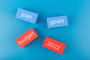 Business plan concept 2022. Text budget, plan, goals 2022 written on colored rectangles on dark...