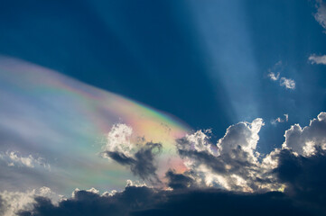 Sunbeams through clouds showing colors in the sky, the phenomenon is called irisation.