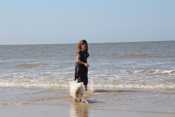Girl and dog paddling in the sea on a summer day, Cromer © BC-Consulting