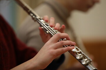 Children's hand holding musical instrument playing flute background image close-up selective focus