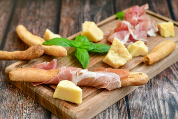 Slices Of  Traditional Italian antipasti  Prosciutto Crudo on a wooden  cutting board .Raw ham