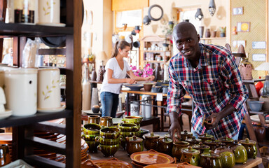 Portrait of young African American male customer visiting pottery shop