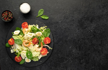 Fresh seafood salad. Grilled shrimp, fresh vegetable salad and egg. Fried shrimps. Healthy food on stone background with copy space for your text