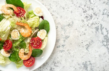 Fresh seafood salad. Grilled shrimp, fresh vegetable salad and egg. Fried shrimps. Healthy food on stone background with copy space for your text
