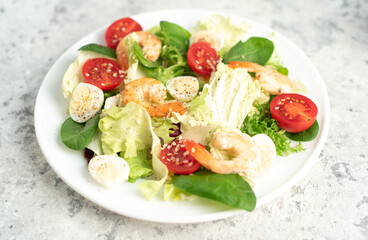 Fresh seafood salad. Grilled shrimp, fresh vegetable salad and egg. Fried shrimps. Healthy food on stone background