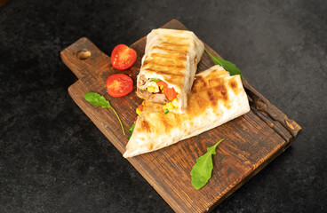 Burrito wraps with grilled beef and vegetables on a stone background. Mexican food.