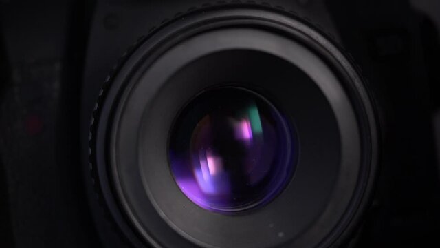 Close-up footage of aperture adjusting in a camera: diaphragm blades of a fixed lens closing and opening. 