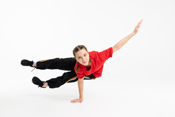 Young female breakdancer doing stunt in the white background