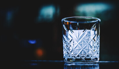 Ice cube in an empty glass on a bar counterin bar or pub