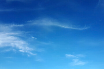 Blue sky with sparse white clouds, can be used as background