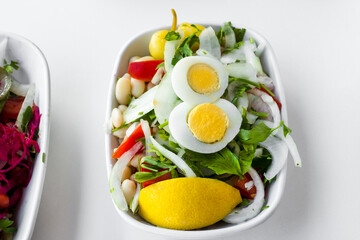 Turkish white bean salad called Piyaz on white table,above view