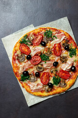 Pizza with bacon, mushrooms, tomatoes, cheese and olives. Italian food.