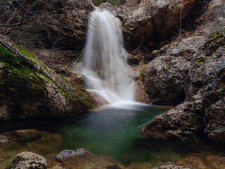 Deep forest winter creek waterfall. Pure nature landscape. in mountain European forest.