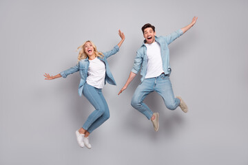 Full length photo of young couple happy positive smile jump up air fly isolated over grey color...