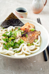 Traditional Japanese udon fish ramen soup with noodles and bonito flakes served as close-up in a...