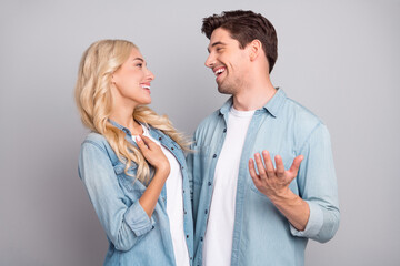 Photo of cute pretty young couple dressed jeans shirts smiling embracing talking isolated grey color background