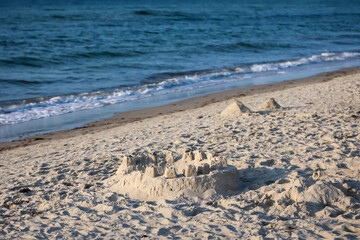 Eine runde große Sandburg am Strand der Ostsee.