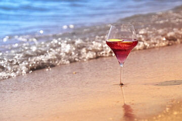 Wine glass with a cocktail by the sea.