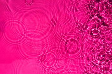 abstract calm rippling water of the rain drop texture in pink color. a background pattern of the...