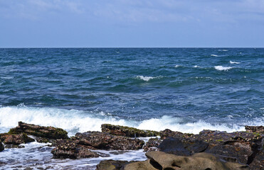 Fototapeta na wymiar View from the rocky coast to the sea on a sunny day